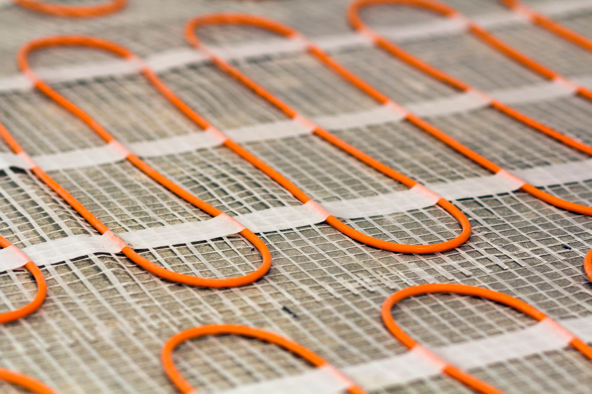 Närbild av elektrisk golvvärmematta som installeras vid badrumsrenovering.