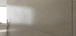 Närbild av ljusgrå microcement på badrumsvägg med minimal design.