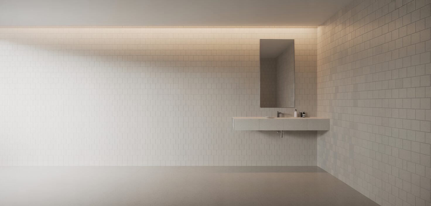 Minimalist badrum med vit kakel och spegel.