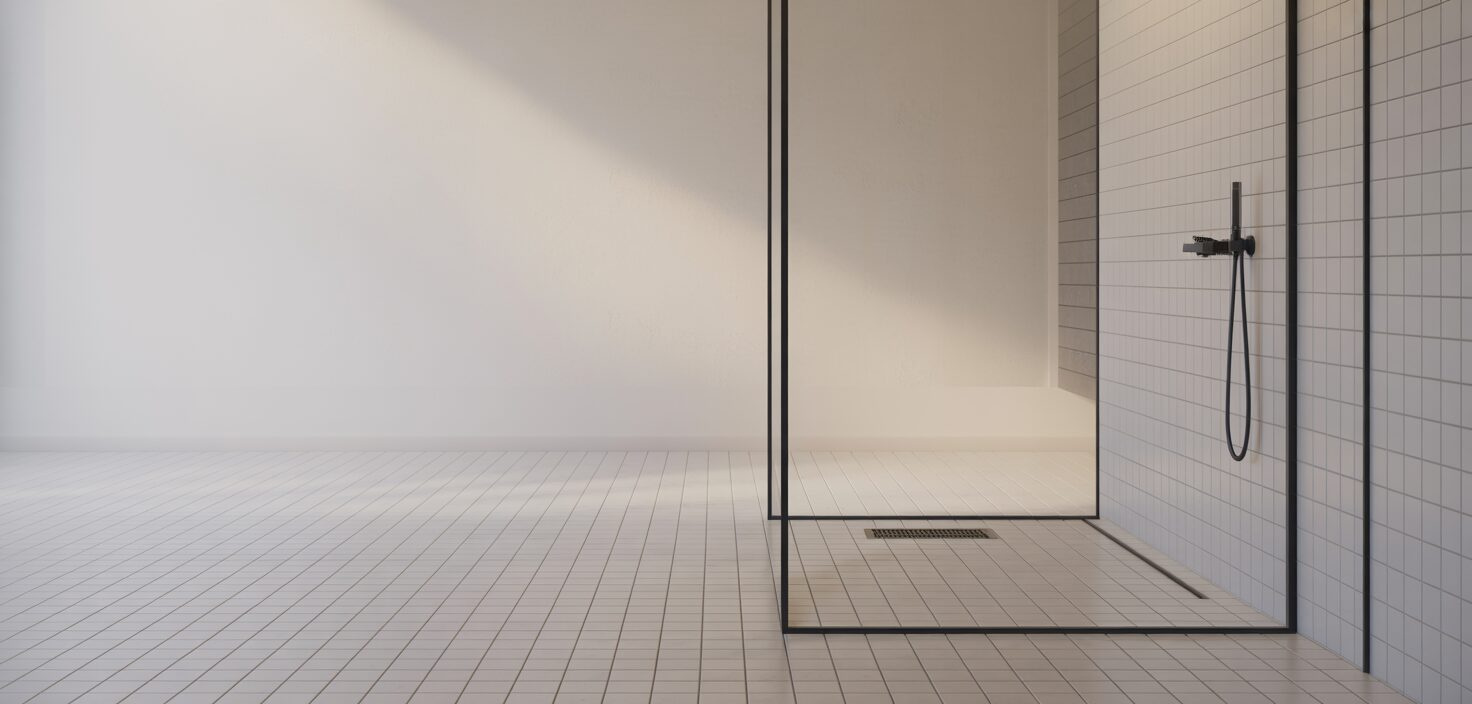 Minimalist badrum med golvvärme och glassdusch, fotograferat i naturligt ljus.