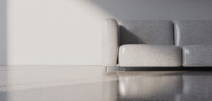 Närbild av ljusgrått terrazzo-golv med subtilt mönster, belyst av naturligt ljus.