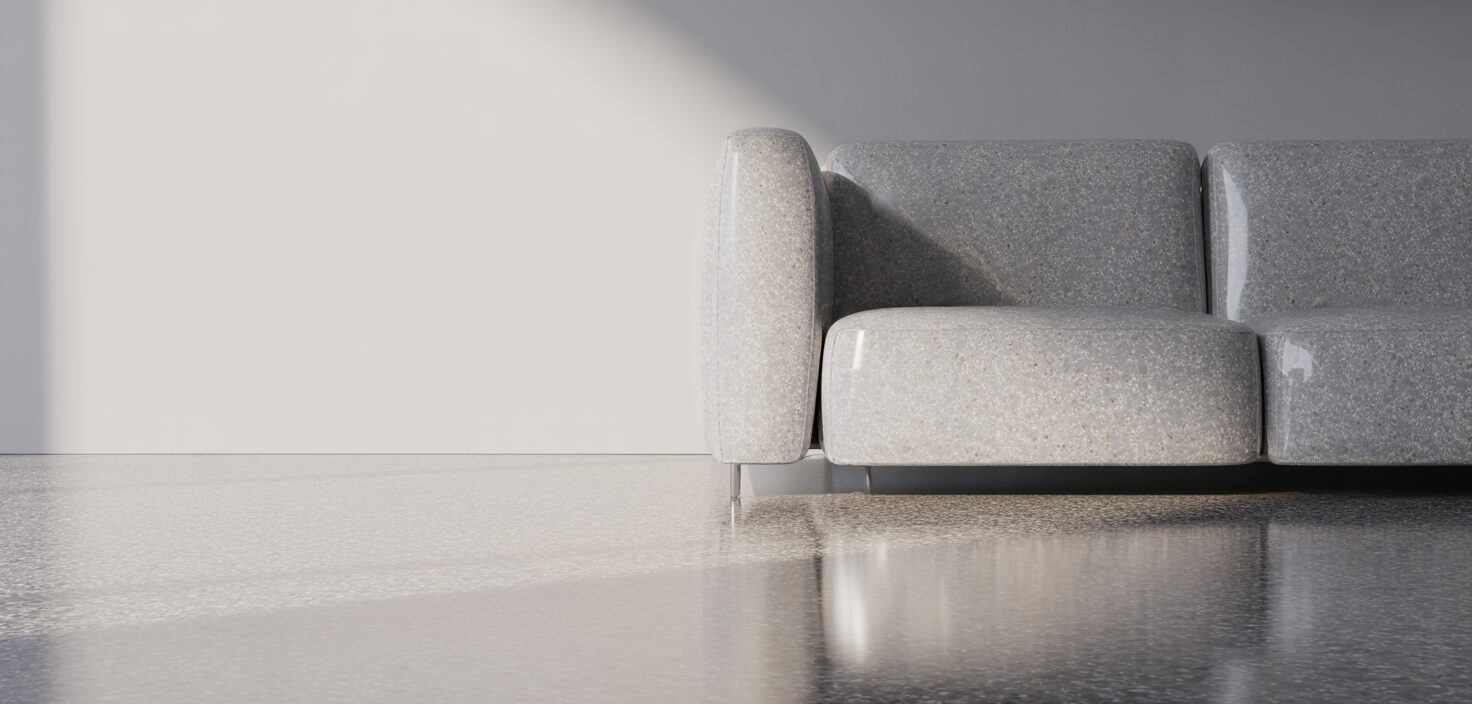 Närbild av ljusgrått terrazzo-golv med subtilt mönster, belyst av naturligt ljus.