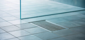 Fotorealistisk bild av en minimalistisk walk-in dusch med en kaklad golvbrunn och lutande kakel.